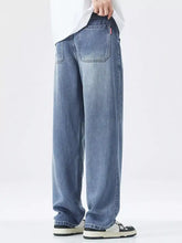 Men’s relaxed fit wide leg vintage wash jeans back view showing light-wash blue denim with classic back pockets