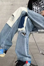 Men’s ripped patchwork wide leg distressed denim jeans featuring white and dark blue fabric with knee rips