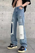 Men’s light-wash denim ripped patchwork wide leg jeans with distressed patches and dark blue and white fabric accents