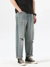 Men’s light-wash denim ripped relaxed fit jeans with distressed details and rolled cuffs for casual wear