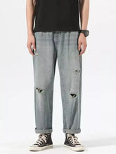 Men’s light-wash denim ripped relaxed fit jeans with distressed details on knees and thighs for casual wear