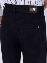 Men’s slim fit jeans in black denim featuring a sleek design with red and white stripes on the back pocket