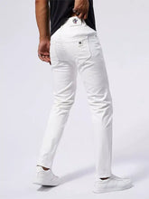 Back view of men’s slim fit white denim jeans with subtle fade and branded patches on waistband and pocket