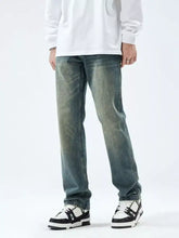 Men’s slim fit jeans in distressed blue denim with a faded worn-in look and subtle fading along the legs