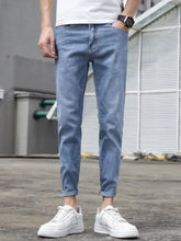 Men’s slim fit wash jeans in light-wash denim with rolled cuffs and a modern slim fit design