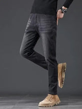 Men’s slim fit wash jeans in dark-wash denim with subtle fading along the thighs and a slim silhouette