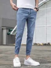 Men’s slim-fit light blue denim wash jeans with rolled cuffs showcasing a modern slim fit design