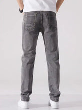 Men’s dark gray slim fit washed denim jeans showing classic back pockets from the back side view