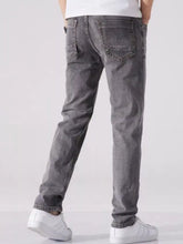 Dark gray slim fit washed denim jeans with faded wash and classic back pockets shown from the back side