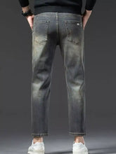 Men’s straight leg vintage wash jeans in dark gray faded denim showing the back side with classic pockets