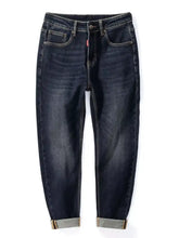 Men’s straight leg washed dark indigo denim jeans with classic five-pocket design and rolled cuffs