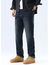 Men’s dark-wash denim jeans with straight leg washed cut and visible stitching along the seams