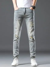 Men’s vintage distressed light wash skinny jeans in denim with ripped details and subtle paint-splatter accents