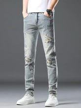 Men’s vintage distressed light wash skinny jeans made of denim with ripped and subtle paint-splatter details