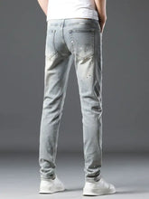 Men’s vintage distressed light wash skinny jeans with subtle distressing and white paint splatter details