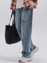 Men’s vintage distressed relaxed fit jeans in light-wash denim with a torn knee and straight-leg fit jeans design