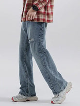 Men’s vintage light-wash denim relaxed fit jeans with a distressed tear at the knee and straight-leg cut fit jeans