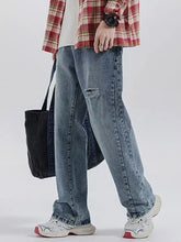 Men’s vintage distressed relaxed fit jeans in light-wash denim with a knee tear and straight-leg fit jeans design