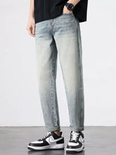 Men’s vintage distressed straight leg jeans in light-wash denim with a relaxed fit and rolled cuffs