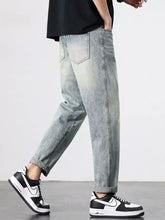Men’s vintage distressed straight leg jeans in light-wash denim with relaxed tapered fit and rolled cuffs