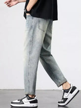 Men’s vintage distressed straight leg jeans in light-wash denim with relaxed tapered fit and rolled cuffs