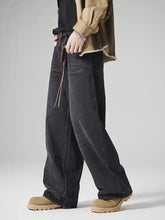 Men’s dark-wash denim jeans with a loose fit vintage wash, wide-leg cut, frayed hem, and braided leather cord detail