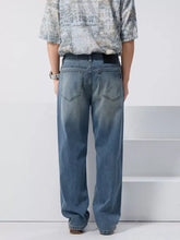 Men’s vintage wash loose fit jeans in light-wash denim with a relaxed wide-leg cut and classic back pockets shown from the back