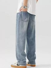 Men’s vintage wash loose fit light-wash denim jeans with relaxed wide-leg cut and classic back pockets back view