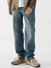 Men’s washed blue denim jeans featuring a vintage wash loose fit with a relaxed straight-leg cut