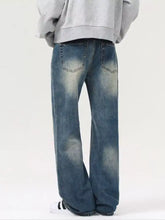Men’s vintage wash loose fit wide-leg denim jeans with faded distressed blue wash and classic back pockets viewed from the back