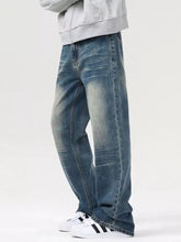 Men’s vintage wash loose fit wide-leg denim jeans in faded blue with subtle whiskering and reinforced stitching