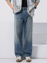 Men’s vintage wash loose fit jeans in faded blue denim with subtle distressing and classic stitching