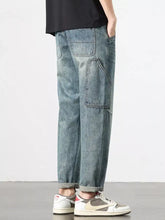 Men’s vintage wash relaxed fit jeans in light-wash denim with reinforced stitching and multiple cargo pockets