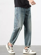 Men’s vintage wash relaxed fit jeans in light-wash denim with tapered legs and visible cargo pockets