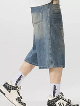 Men’s vintage wash wide-leg capris jeans in blue denim with faded wash and black text pattern along the side seam