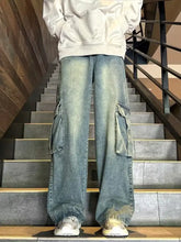 Men’s vintage wash wide leg cargo jeans in faded blue denim with large side pockets and a relaxed fit