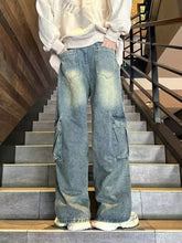Men’s vintage wash wide leg cargo jeans in faded blue denim with large cargo pockets for casual wear