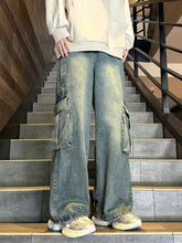 Men’s vintage wash wide leg cargo jeans in faded blue denim with large side cargo pockets