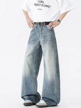 Men’s vintage wash wide leg jeans in faded blue denim with subtle distressing and a vintage wash wide design