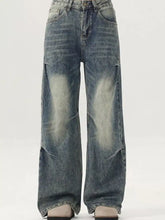 Men’s vintage wash wide leg jeans in faded blue denim with distressed patches on the thighs