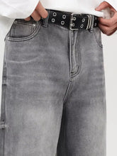 Black double-loop belt with silver hardware and circular eyelets paired with men’s vintage wash wide leg jeans