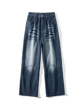 Men’s dark blue denim vintage wash wide leg jeans with a faded wave-like distress pattern across the front