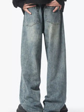 Men’s vintage wash wide leg jeans in faded blue denim with subtle distressing and classic back pockets shown from back side