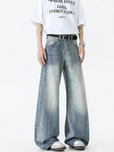 Men’s vintage wash wide leg jeans in faded blue denim with subtle distressing and a vintage wash wide design