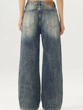 Men’s vintage wash wide leg jeans in faded blue denim with subtle distressing and classic wide leg design