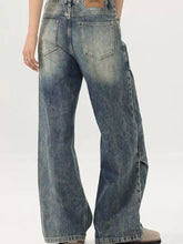 Men’s vintage wash wide leg jeans in faded blue denim with subtle distressing and a relaxed fit