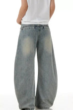 Men’s vintage wash wide leg jeans in faded light blue denim with subtle distressing and a relaxed loose fit