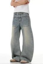 Men’s vintage wash wide leg jeans in faded light blue denim with prominent front pockets and raw hem