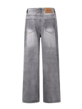 Men’s vintage wash wide leg gray denim jeans with faded wash and brown leather brand patch at waistband
