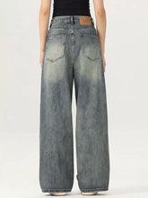 Men’s vintage wash wide leg denim jeans in faded blue with classic back pockets and brown leather brand patch back view